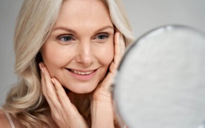 A licensed surgeon holding a mirror for the client result in Facelift Operation in Newport Beach, CA at Dr. George Brennan Clinic